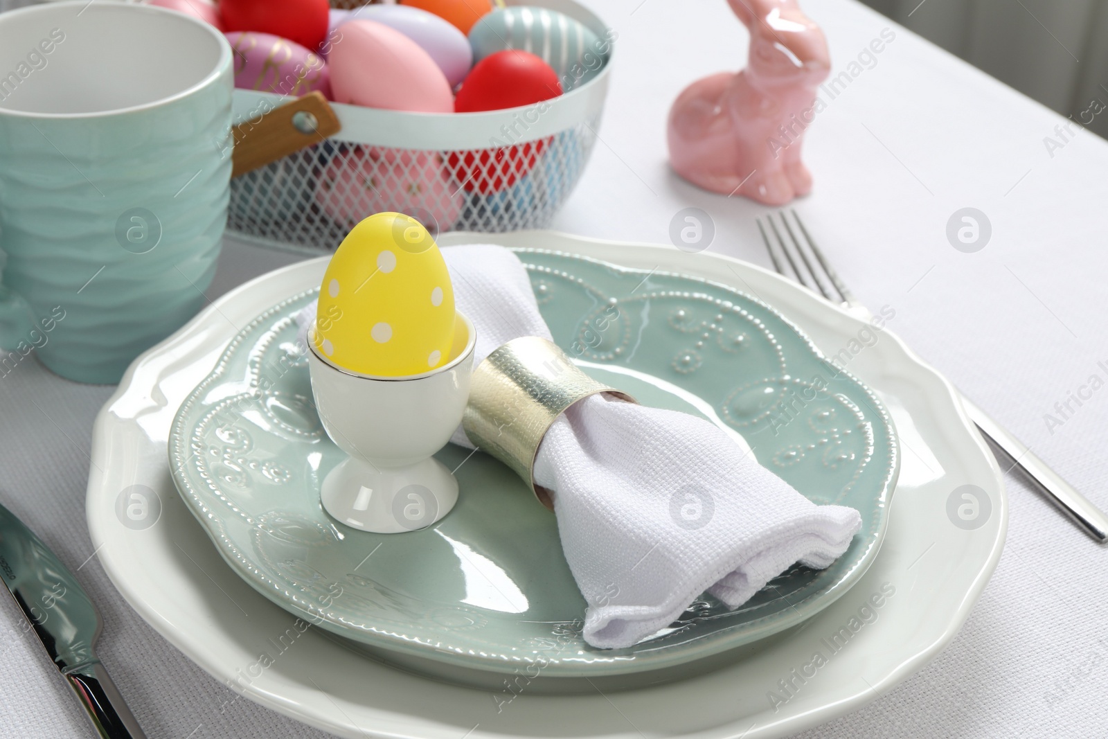 Photo of Festive Easter table setting with painted eggs, closeup