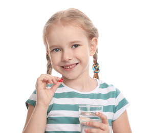 Little girl with vitamin pill and glass of water on white background
