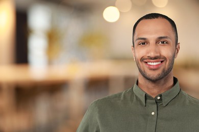 Portrait of handsome confident man in office, space for text