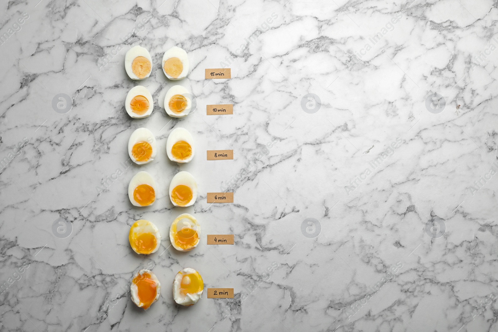 Photo of Various types of boiled eggs on marble background, flat lay with space for text. Cooking time