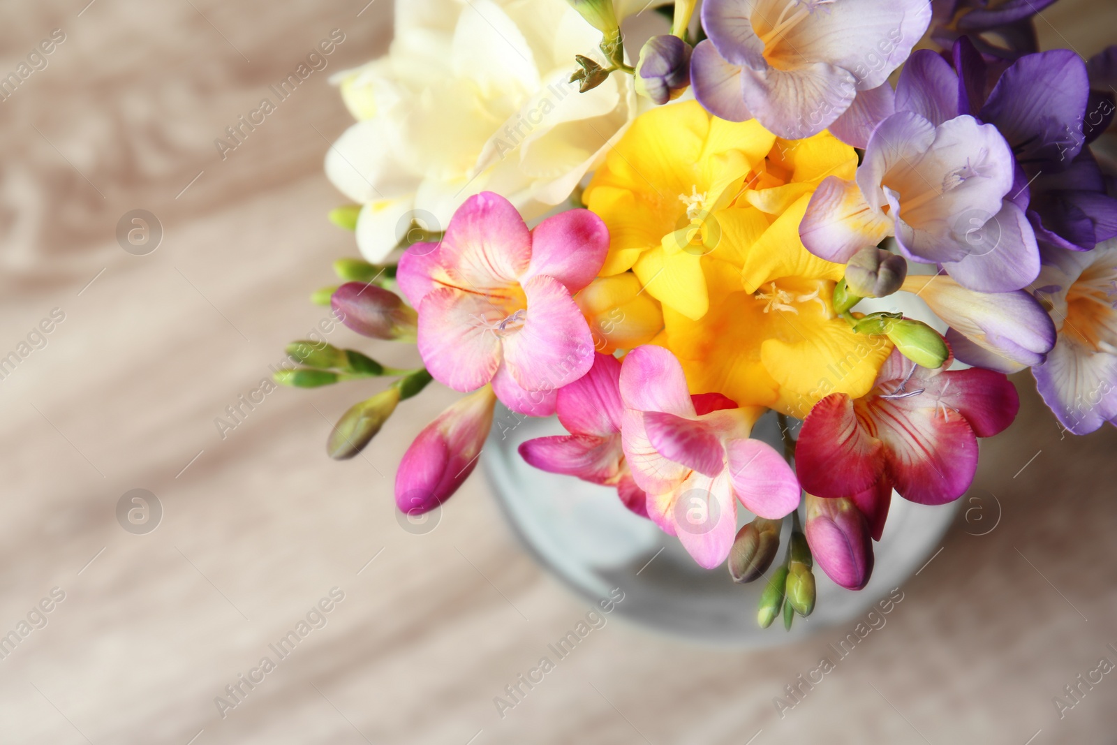 Photo of Beautiful bouquet of freesia flowers on table