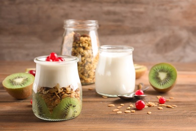 Photo of Tasty breakfast with yogurt and granola on wooden table