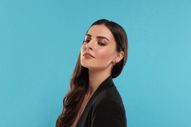 Photo of Beautiful woman with elegant earrings on light blue background