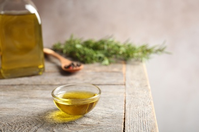 Bowl of rosemary oil on wooden table