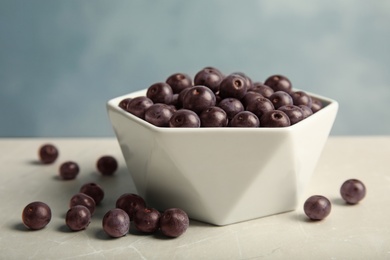 Photo of Bowl with fresh acai berries on table, closeup