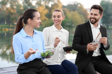 Photo of Smiling business woman talking with her colleagues during lunch outdoors