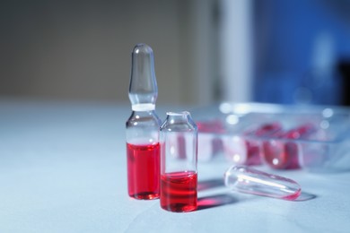 Photo of Pharmaceutical ampoules with medication on white table