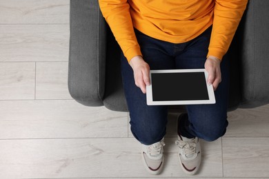 Photo of Man working with tablet in armchair, top view. Space for text