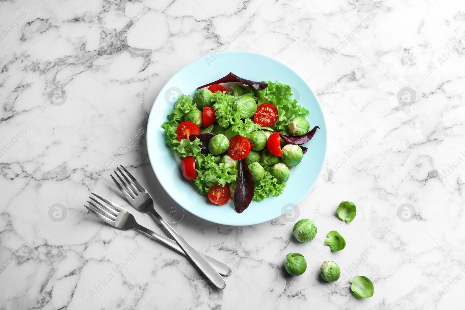 Photo of Tasty salad with Brussels sprouts served on white marble table, flat lay