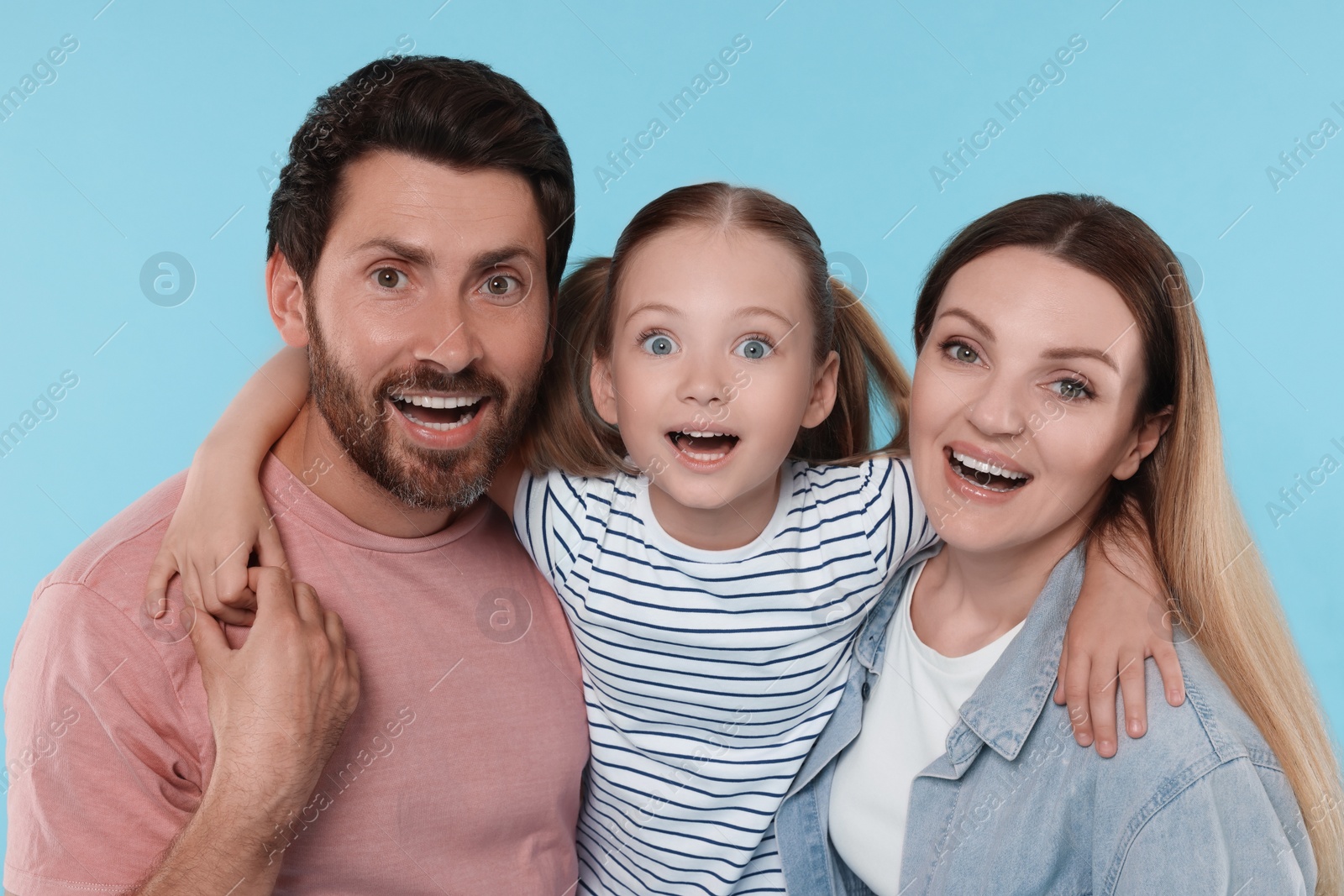 Photo of Happy surprised family on light blue background
