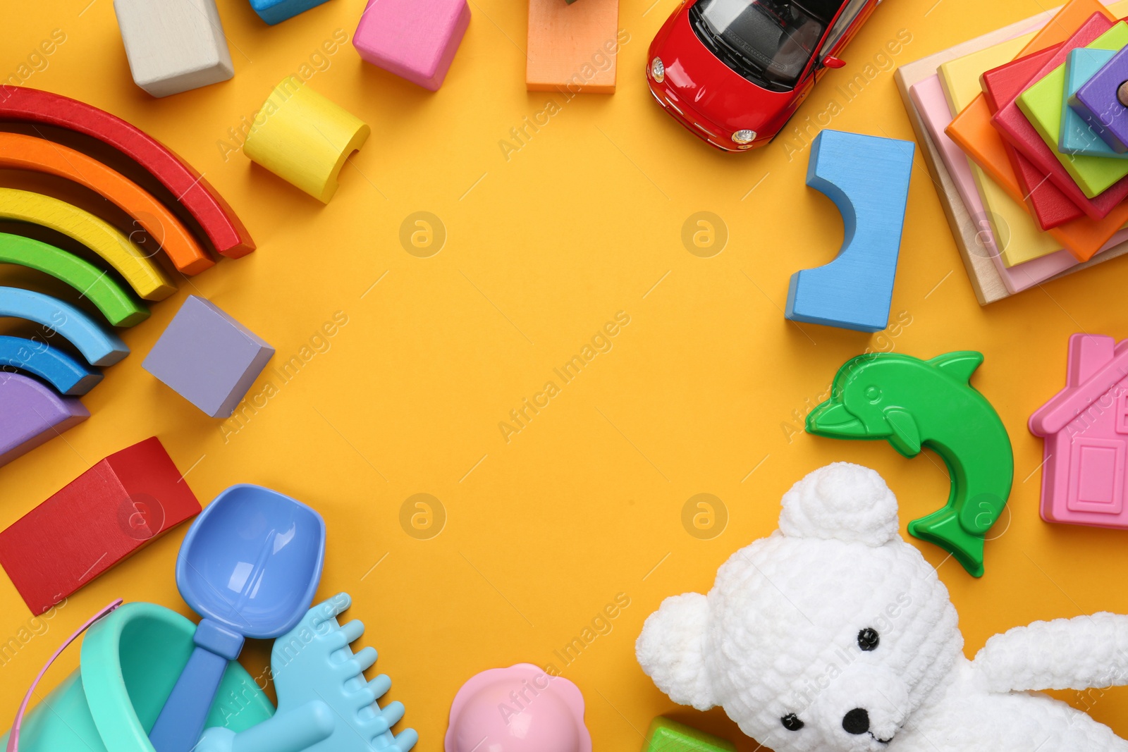 Photo of Frame of different children's toys on yellow background, flat lay. Space for text