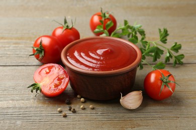 Photo of Tasty ketchup, fresh tomatoes, parsley and spices on wooden table