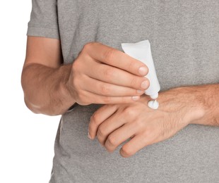 Photo of Man applying cream from tube onto hand on white background, closeup