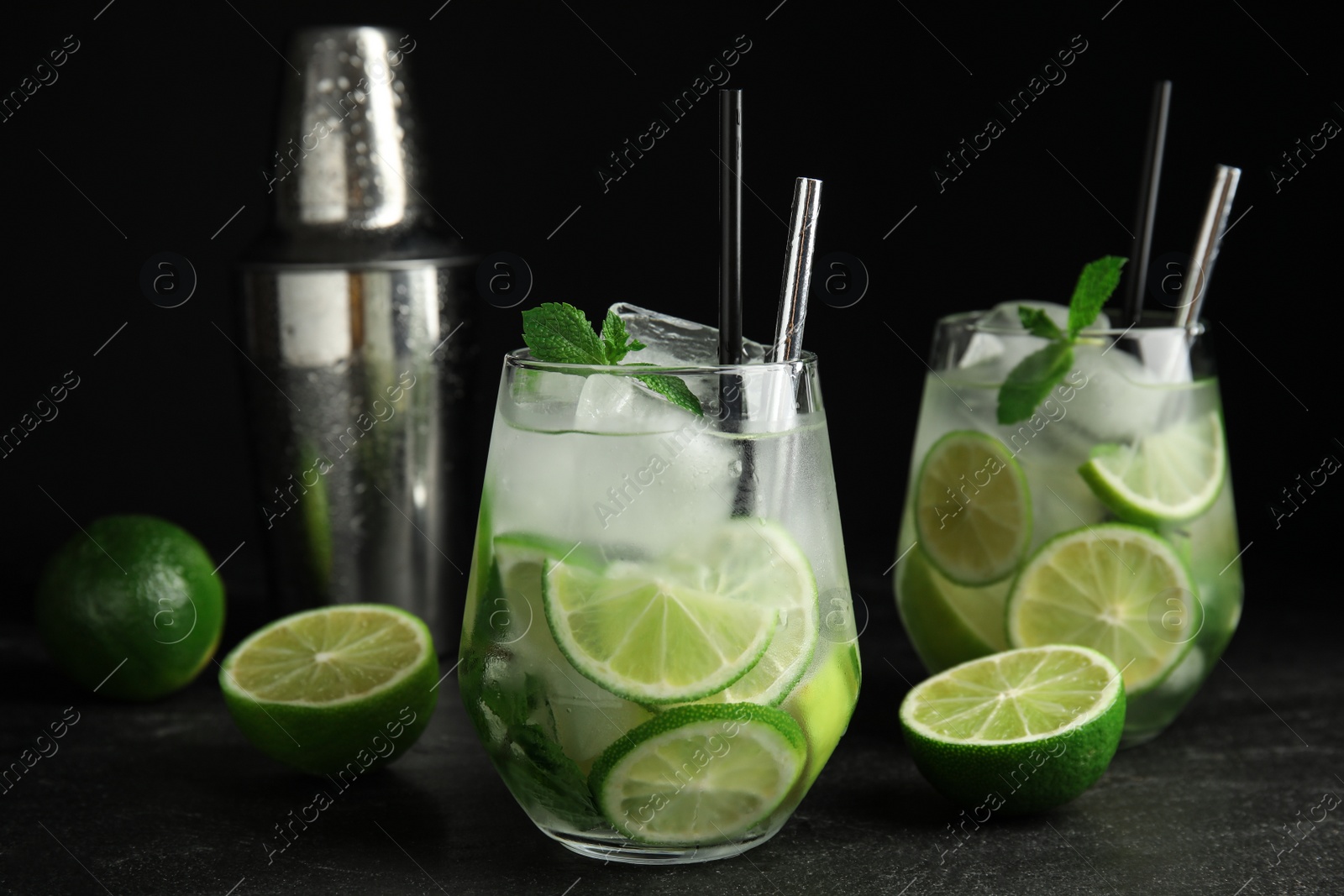 Photo of Delicious mojito and ingredients on black table