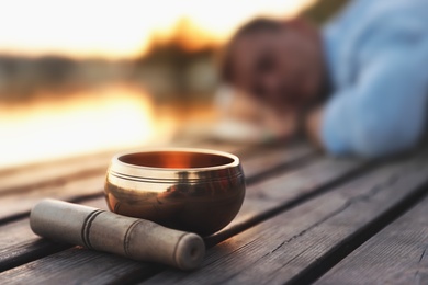 Photo of Man at healing session outdoors, focus on singing bowl