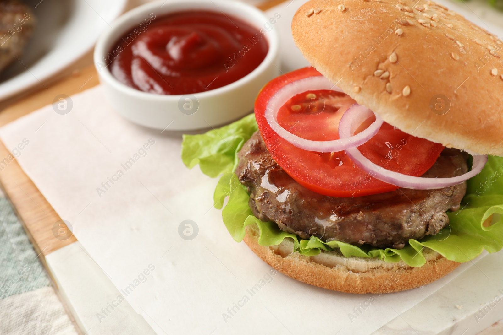 Photo of Tasty hamburger with patty and vegetables served on table, closeup. Space for text