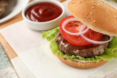 Tasty hamburger with patty and vegetables served on table, closeup. Space for text