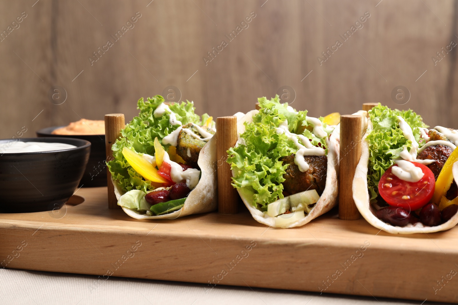 Photo of Delicious fresh vegan tacos served on wooden table