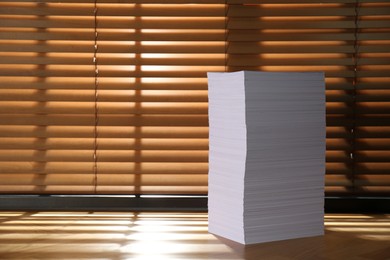 Photo of Stack of paper sheets on wooden table. Space for text