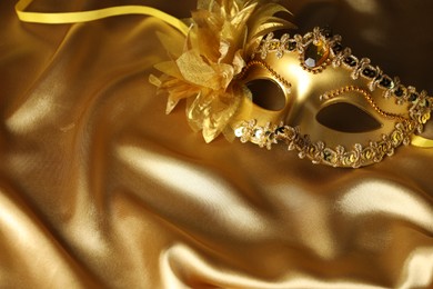 Beautifully decorated face mask on golden fabric, space for text. Theatrical performance