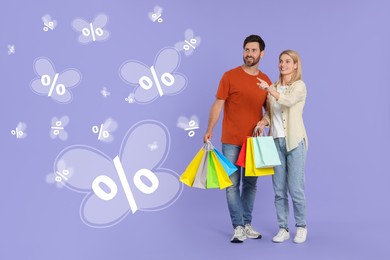 Image of Discount offer. Happy couple with paper shopping bags looking at butterflies with percent signs on purple background