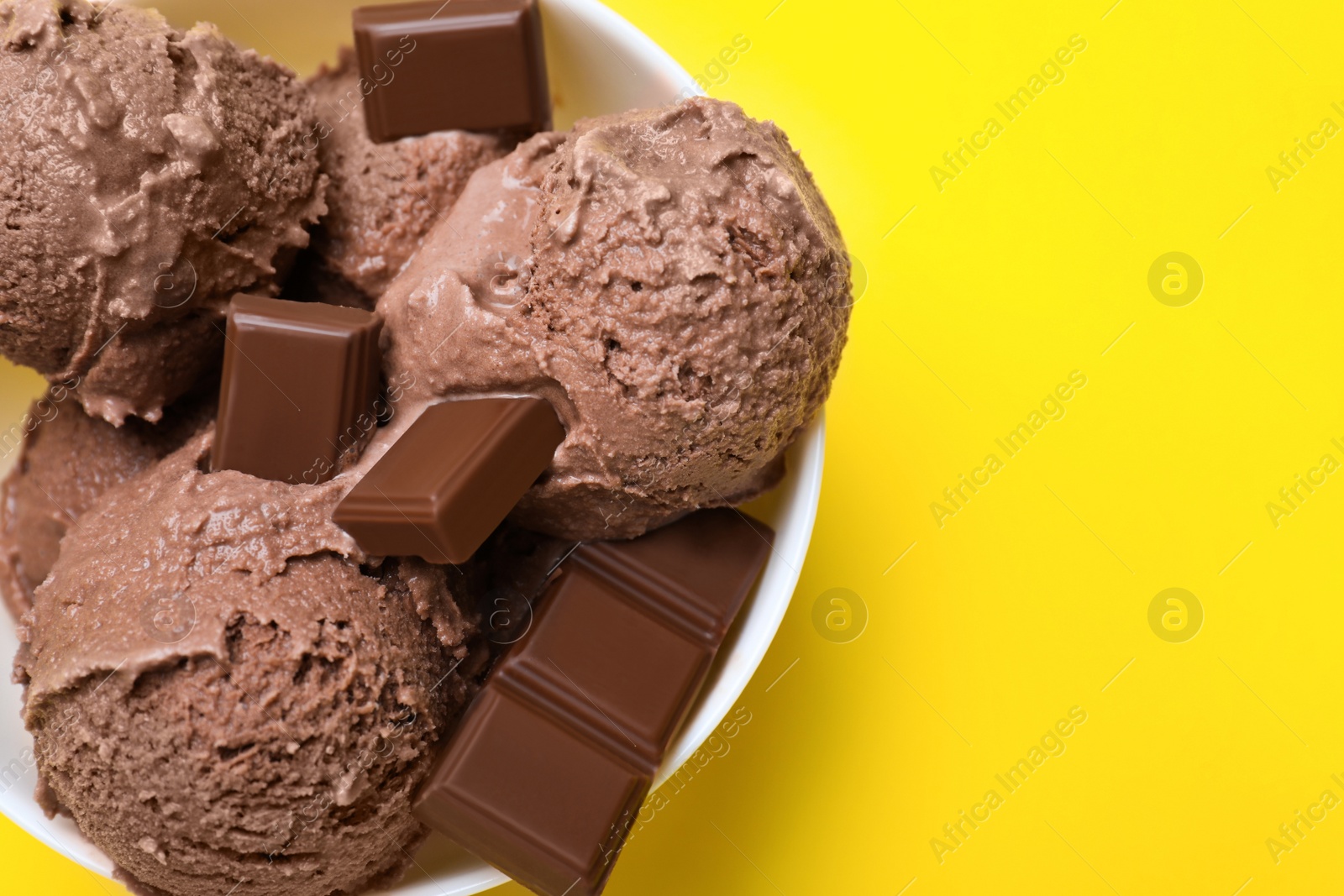 Photo of Delicious chocolate ice cream on yellow background, top view