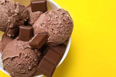 Photo of Delicious chocolate ice cream on yellow background, top view