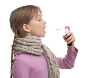 Photo of Little girl with scarf using throat spray on white background