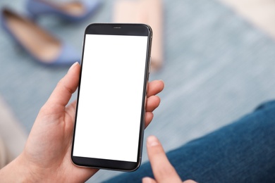 Photo of Woman holding smartphone with blank screen indoors, closeup of hands. Space for text
