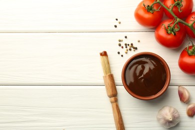 Photo of Flat lay composition with tasty barbeque sauce in bowl on white wooden table. Space for text