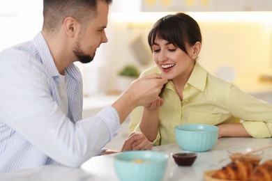 Photo of Tasty breakfast. Husband feeding his wife at home