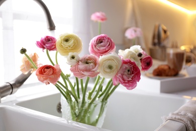 Beautiful fresh ranunculus flowers in kitchen sink
