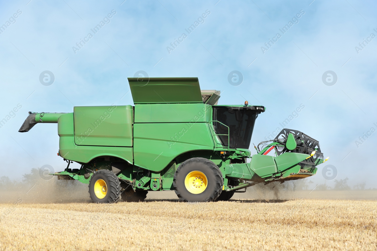 Photo of Modern combine harvester working in agricultural field