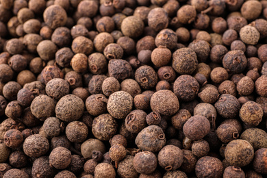 Photo of Black pepper grains as background, closeup view