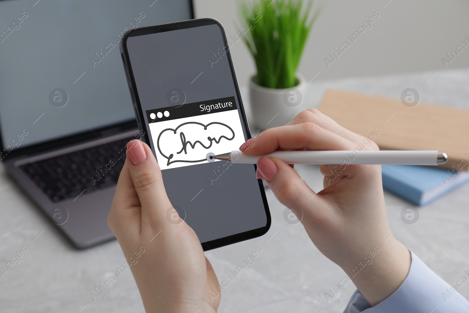 Image of Electronic signature. Woman using stylus and mobile phone at table, closeup