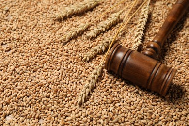 Photo of Wooden gavel and wheat ears on grains, closeup. Agricultural deal