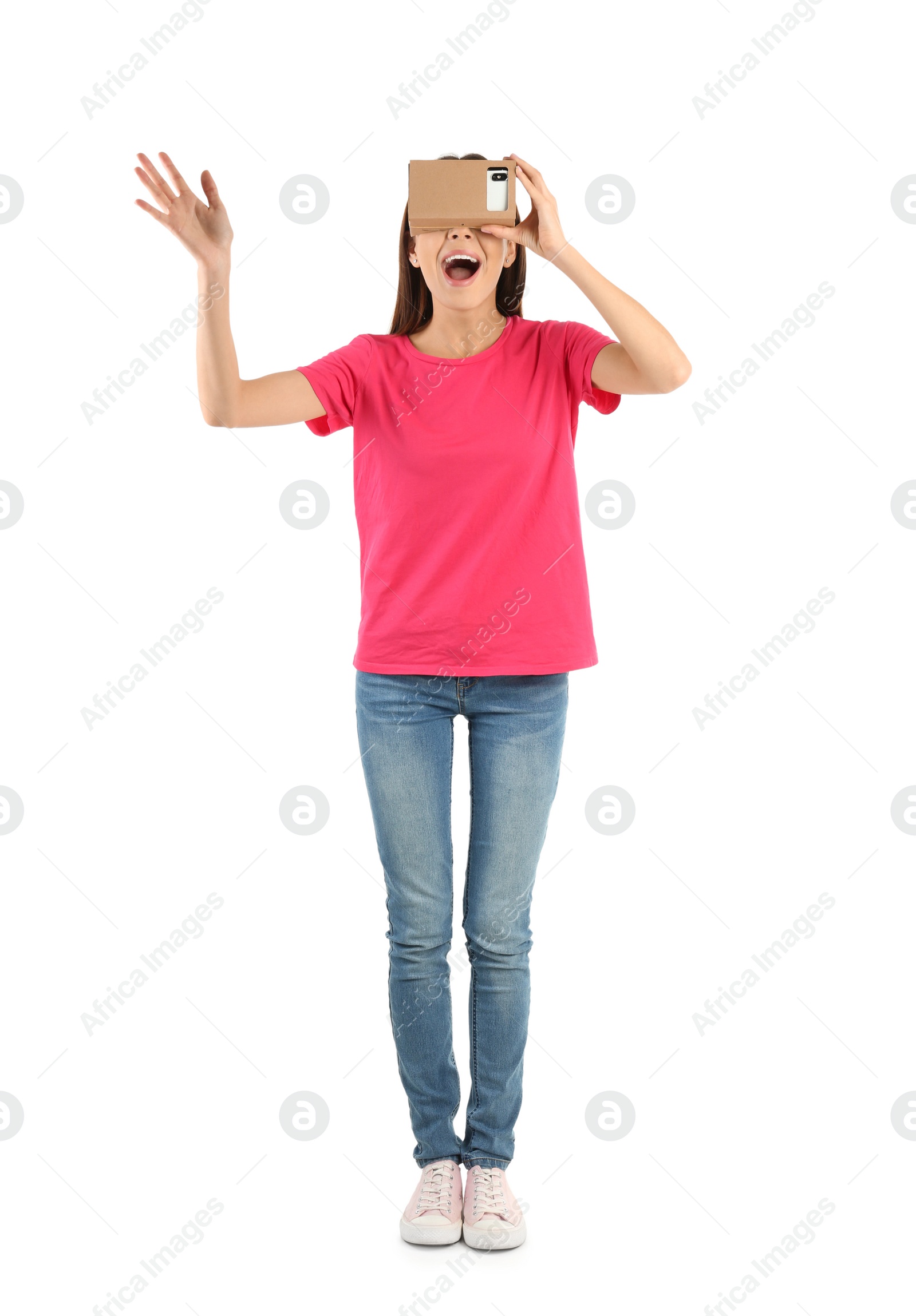 Photo of Young woman using cardboard virtual reality headset, isolated on white