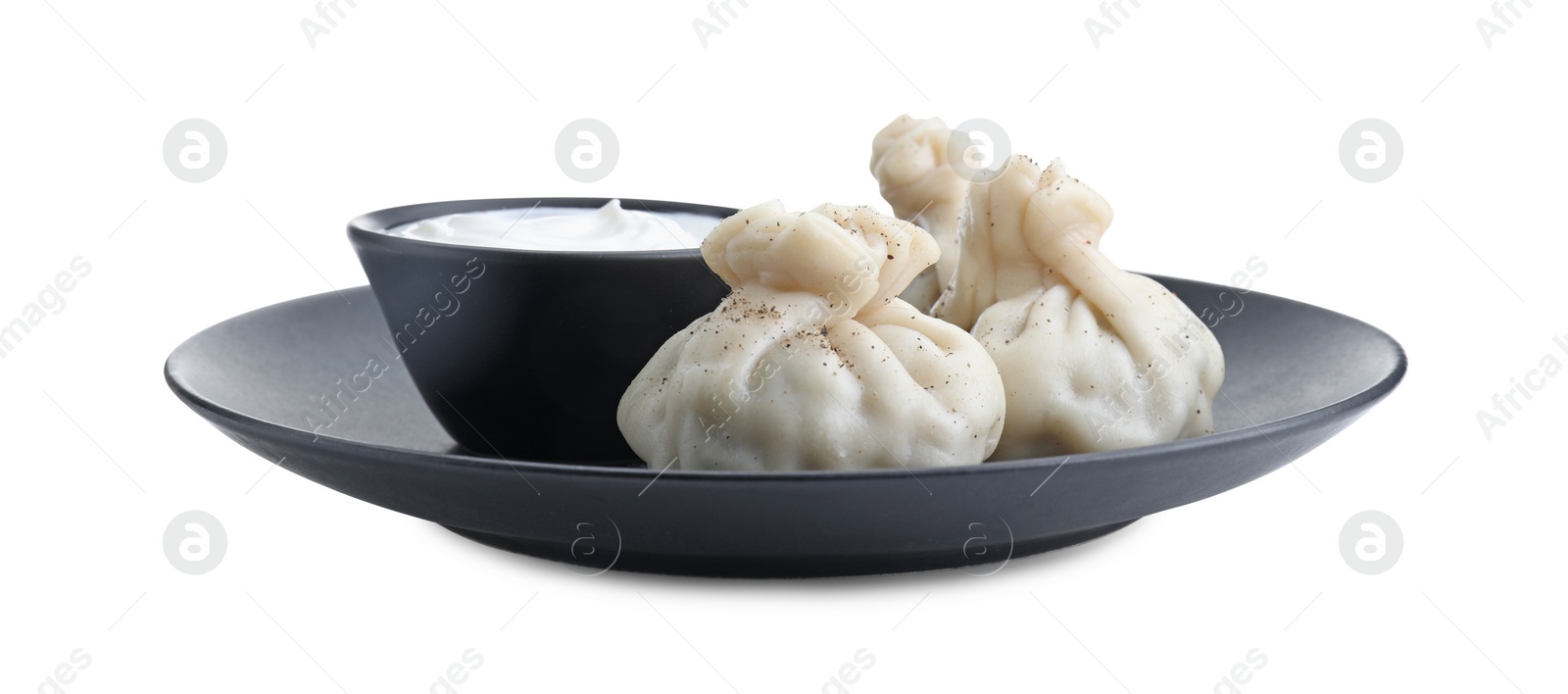 Photo of Tasty khinkali (dumplings) with sauce and spices isolated on white. Georgian cuisine
