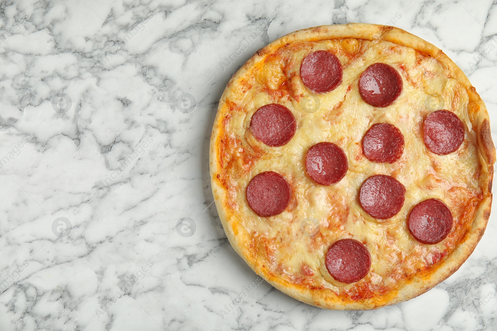 Photo of Tasty pepperoni pizza on white marble table, top view. Space for text