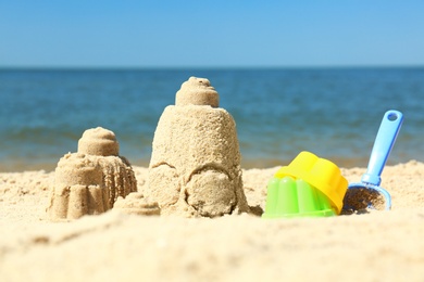 Photo of Beautiful view of beach with sand figures and plastic toys near sea