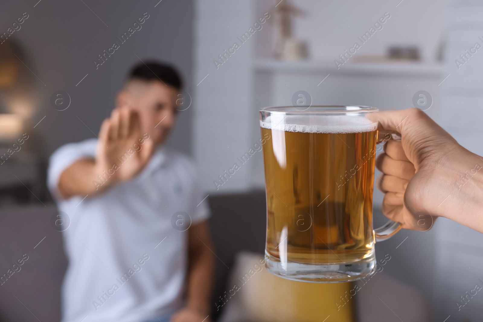 Photo of Man refusing to drink beer in kitchen, closeup. Alcohol addiction treatment