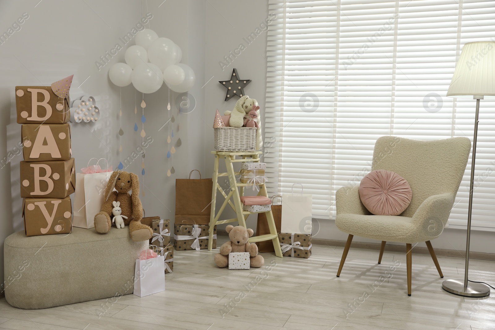 Photo of Baby shower party. Festive decor, gift boxes and toys in stylish room