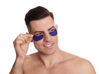 Man applying blue under eye patch on white background