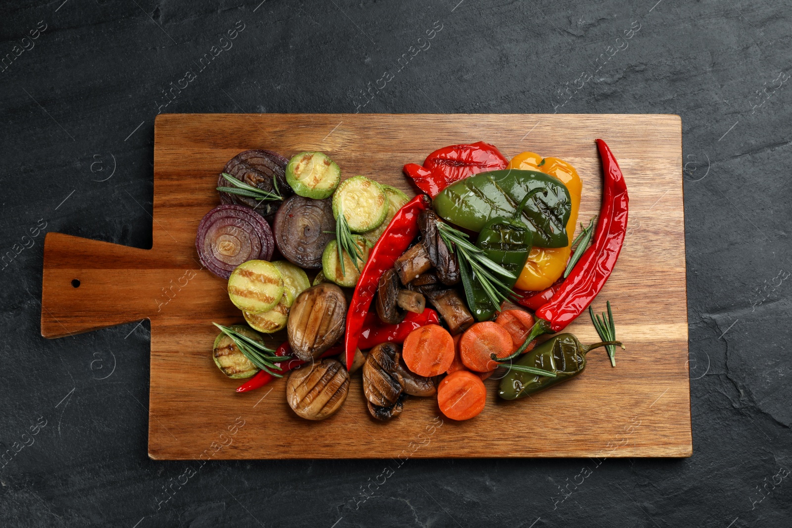 Photo of Delicious grilled vegetables on black table, top view