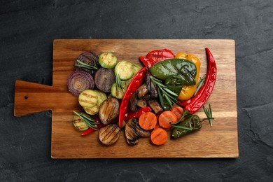 Photo of Delicious grilled vegetables on black table, top view
