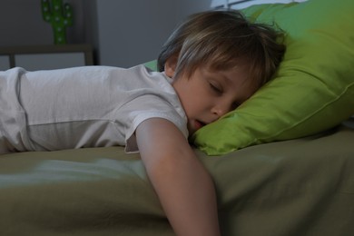 Little boy snoring while sleeping on bed at night