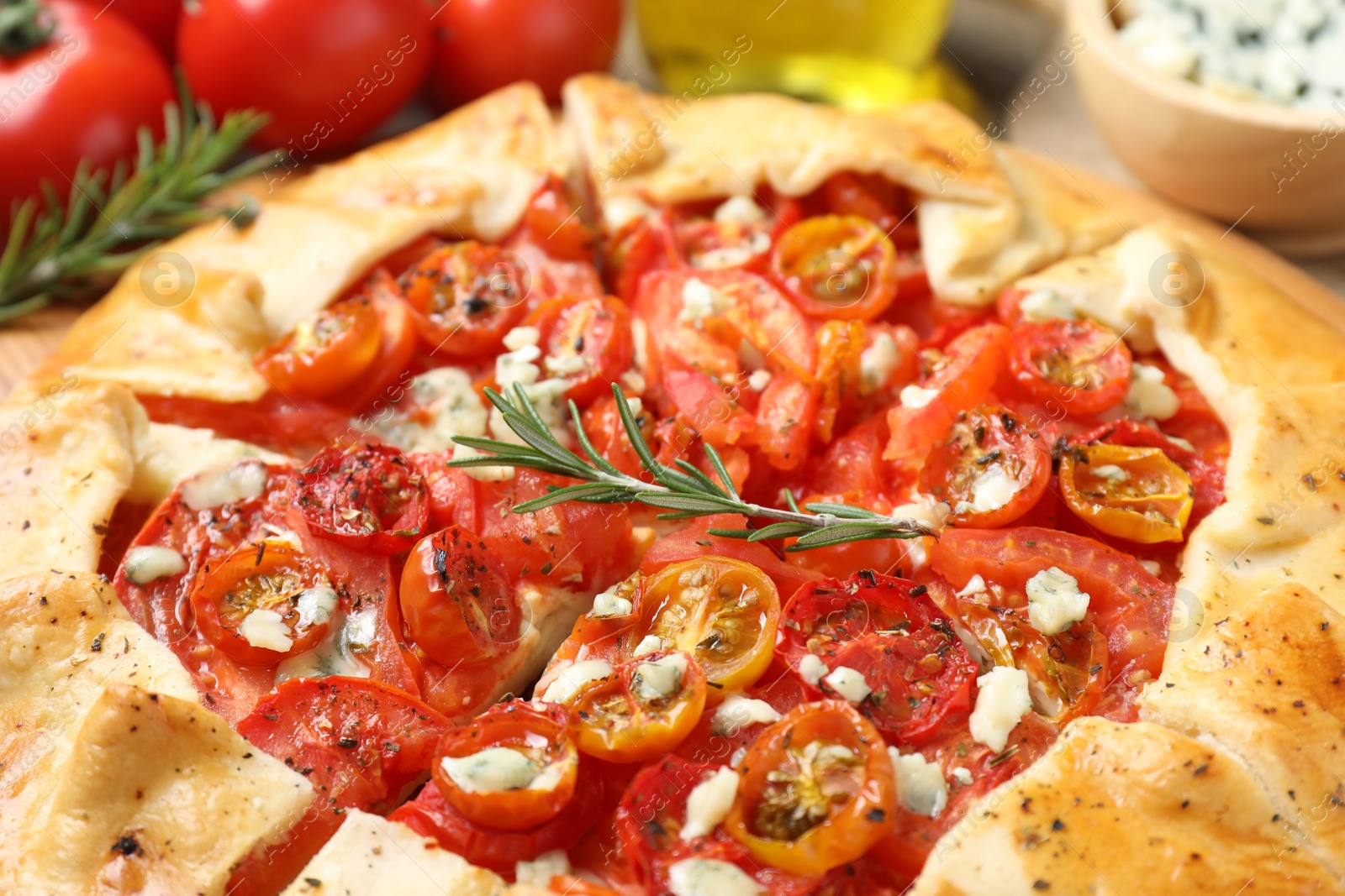 Photo of Tasty galette with tomato, rosemary and cheese (Caprese galette) on table, closeup