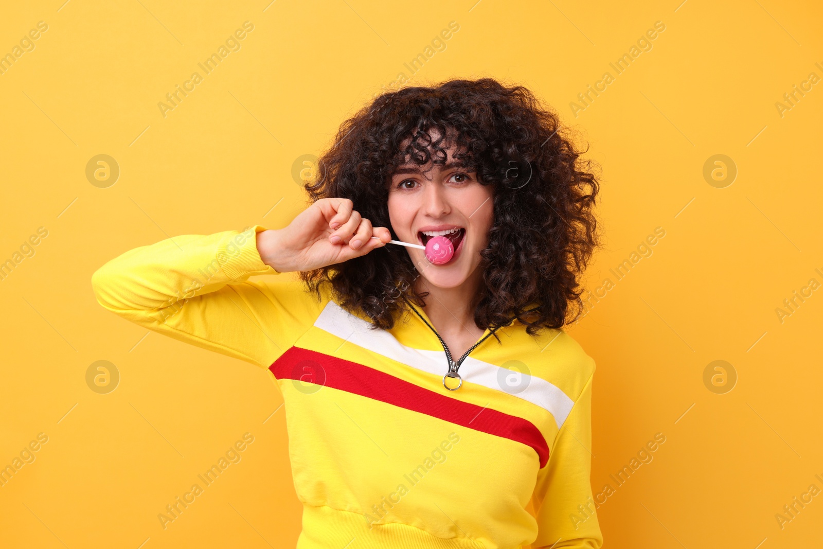 Photo of Beautiful woman with lollipop on yellow background