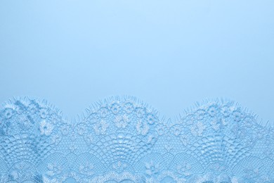 Photo of Beautiful lace on light blue background, top view. Space for text