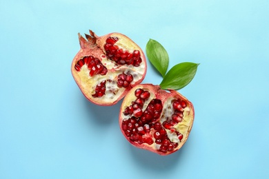 Photo of Ripe pomegranate halves on color background, top view